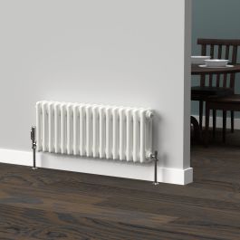 A 300mm x 785mm horizontal 3-column radiator in a White finish with chrome valves within a dining room setting.
