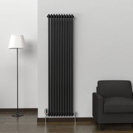 A 1800mm x 470mm 2-Column Vertical Radiator in a Space Black finish with chrome valves within a living room setting.
