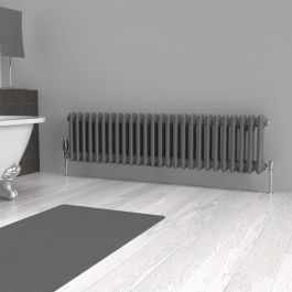A 300mm x 1190mm horizontal 2-column radiator in an Anthracite finish with chrome valves within a bathroom setting.
