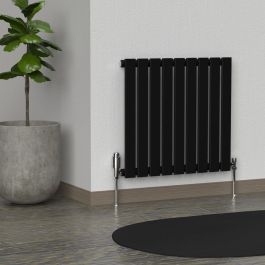 A 600mm x 630mm Horizontal Flat Single Radiator in a Space Black finish with chrome valves within a living room setting.
