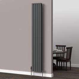 A 1800mm x 300mm vertical oval radiator in an anthracite finish with chrome valves within a kitchen/dining room setting.
