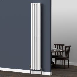 A 1800mm x 300mm vertical oval radiator in an White finish with chrome valves within a dining room setting.
