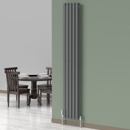 A 1800mm x 300mm Vertical Oval Radiator in a Anthracite finish with chrome valves within a dining room setting.