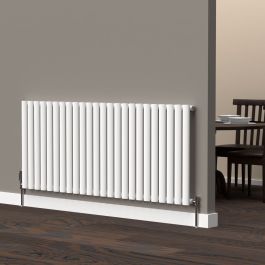 A 600mm x 1440mm horizontal oval radiator in a white finish with chrome valves within a kitchen/dining room setting.