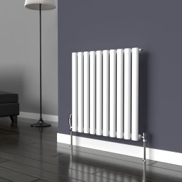 A 600mm x 540mm horizontal oval radiator in a white finish with chrome valves within a living room setting.