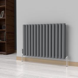 A 600mm x 780mm Horizontal Oval Double Radiator in an Anthracite finish with chrome valves within a living room setting.
