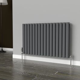 A 600mm x 960mm horizontal oval double radiator in an Anthracite finish with chrome valves within a living room setting.

