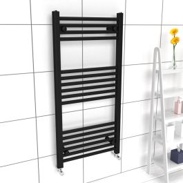 A 1000mm x 500mm 22mm Towel Radiator in a Space Black finish with chrome manual  valves within a bathroom setting.
